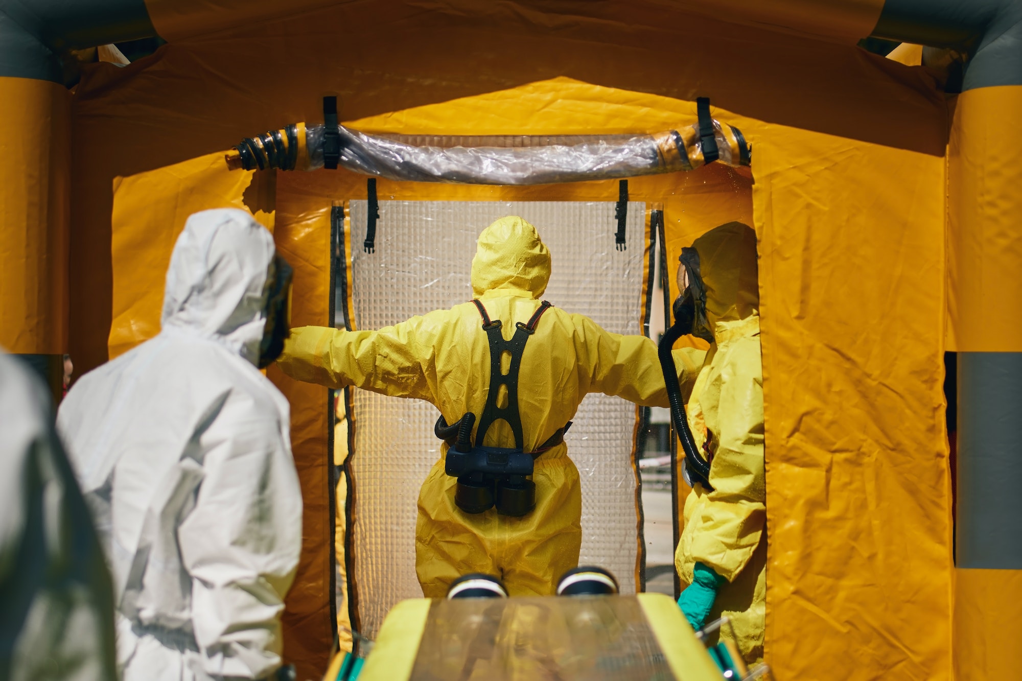 Members of biohazard teams in protective suits